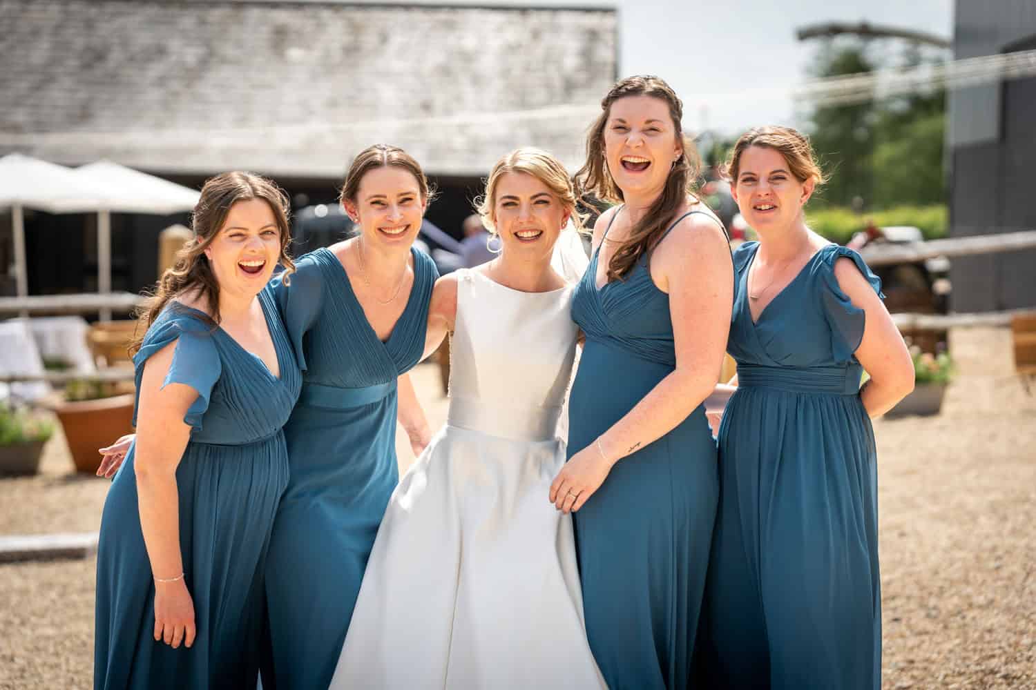 Bride with bridesmaids in blue dresses by Southampton wedding photographer John Watson