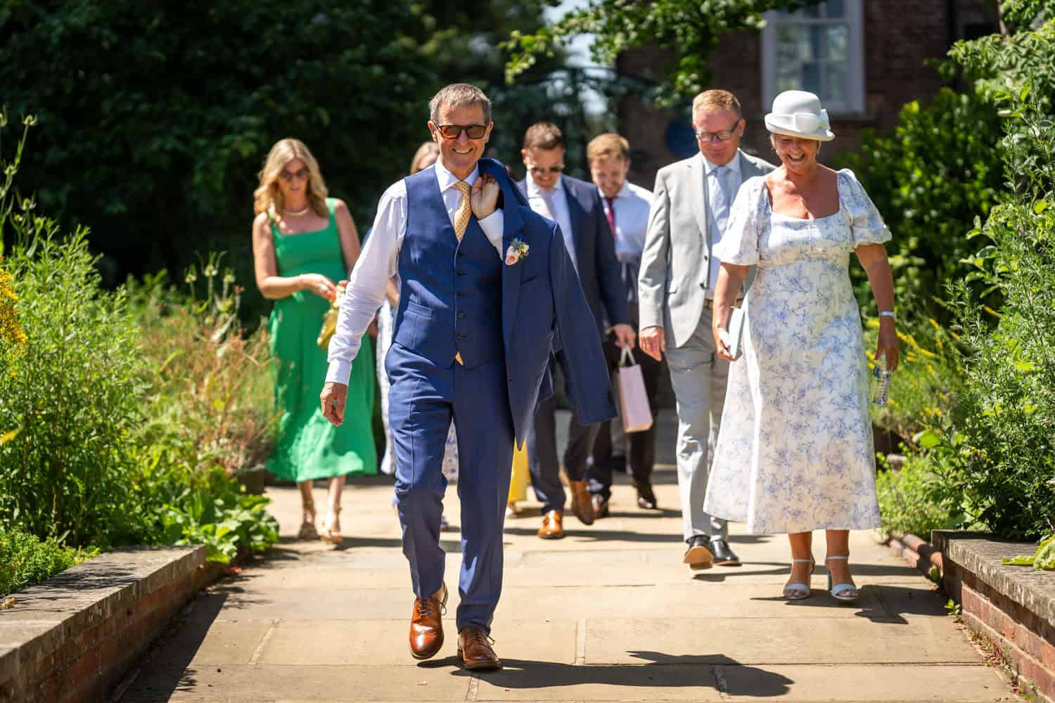 Wedding guests walking together on a sunny day by Southampton wedding photographer John Watson