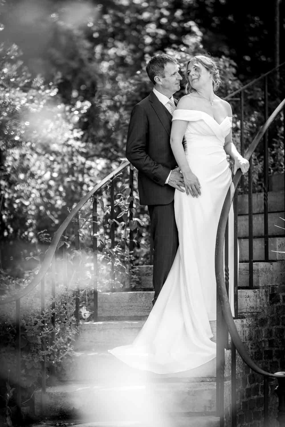 Bride and groom on elegant garden steps by Southampton wedding photographer John Watson