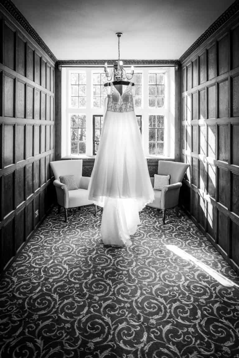 Elegant bridal gown in sunlit room by Southampton wedding photographer John Watson