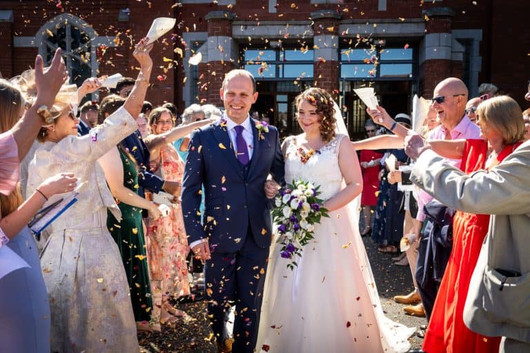 Bride and groom showered in confetti at wedding by Southampton wedding photographer John Watson