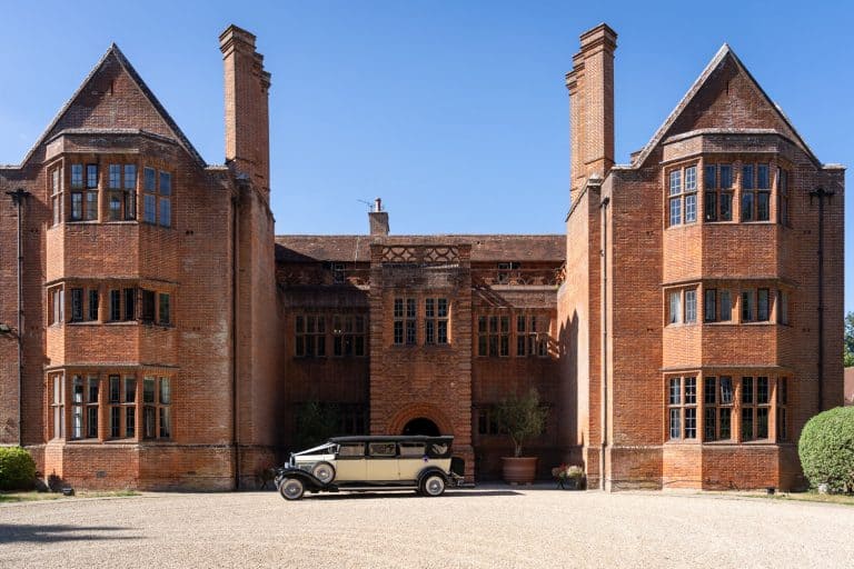 Historic manor house with vintage car by Southampton wedding photographer John Watson